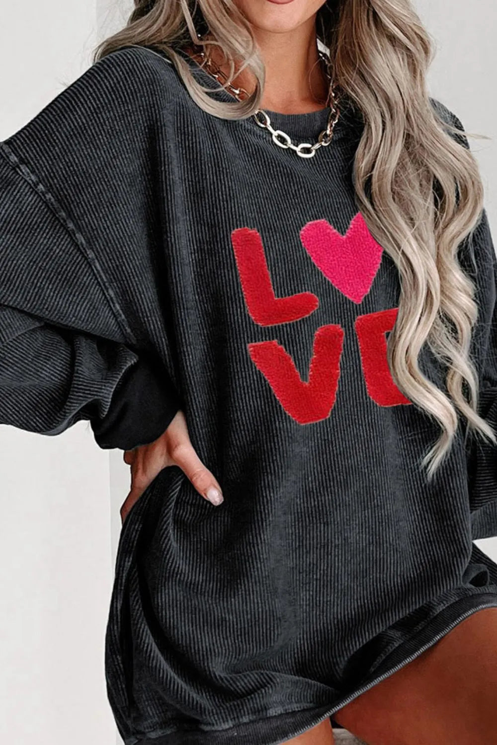 Black long sleeve sweatshirt with red "LOVE" and heart graphic on front.
