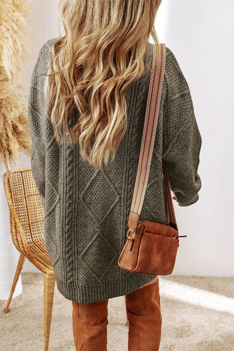 Sage cable-knit sweater dress with diamond pattern, worn with brown suede crossbody bag and matching boots.