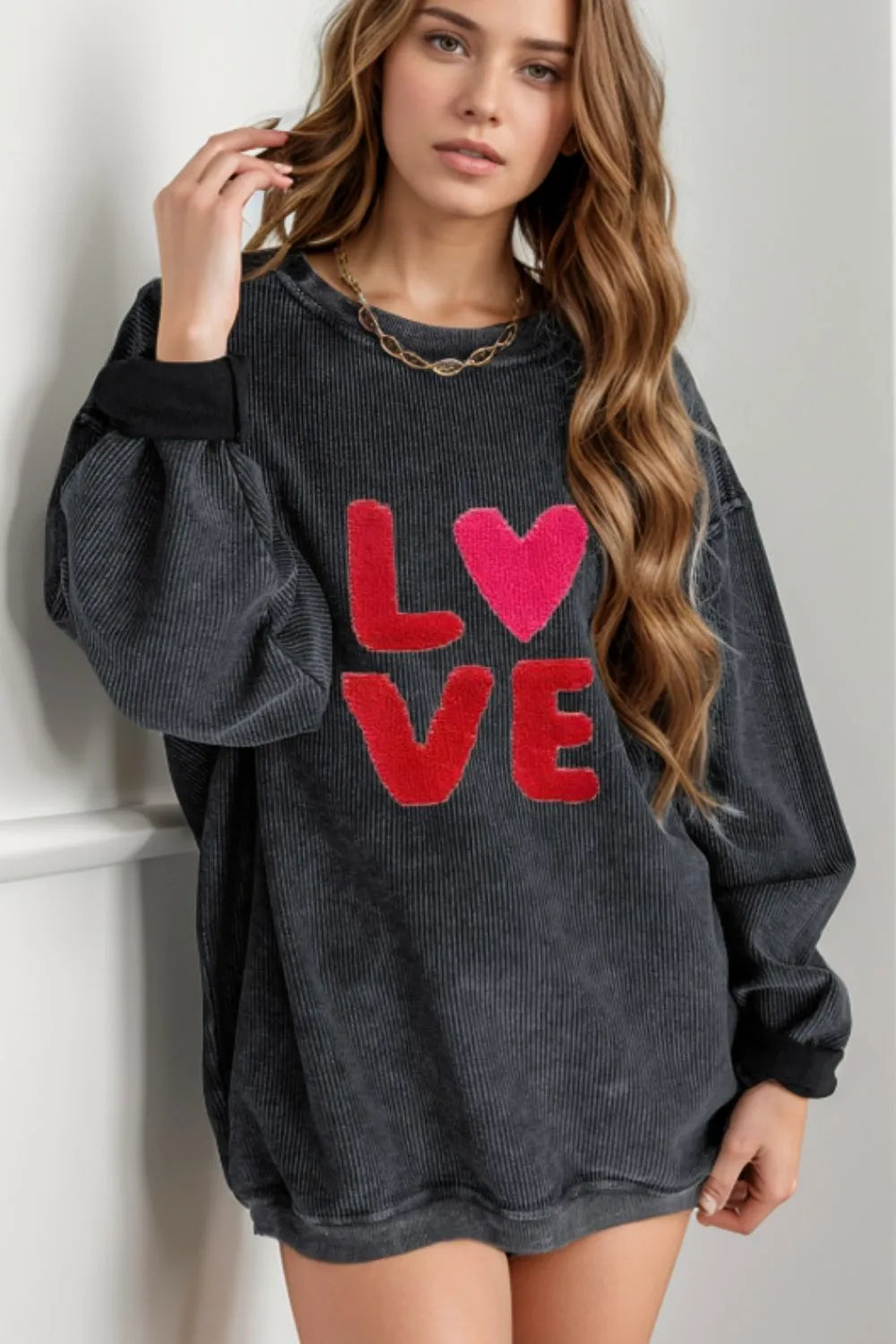 Dark gray long sleeve sweatshirt with red "LOVE" text and heart design on front.