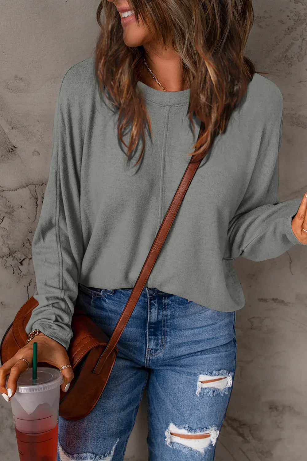 Heather gray full-size round neck long sleeve t-shirt styled with ripped blue jeans and brown crossbody bag.