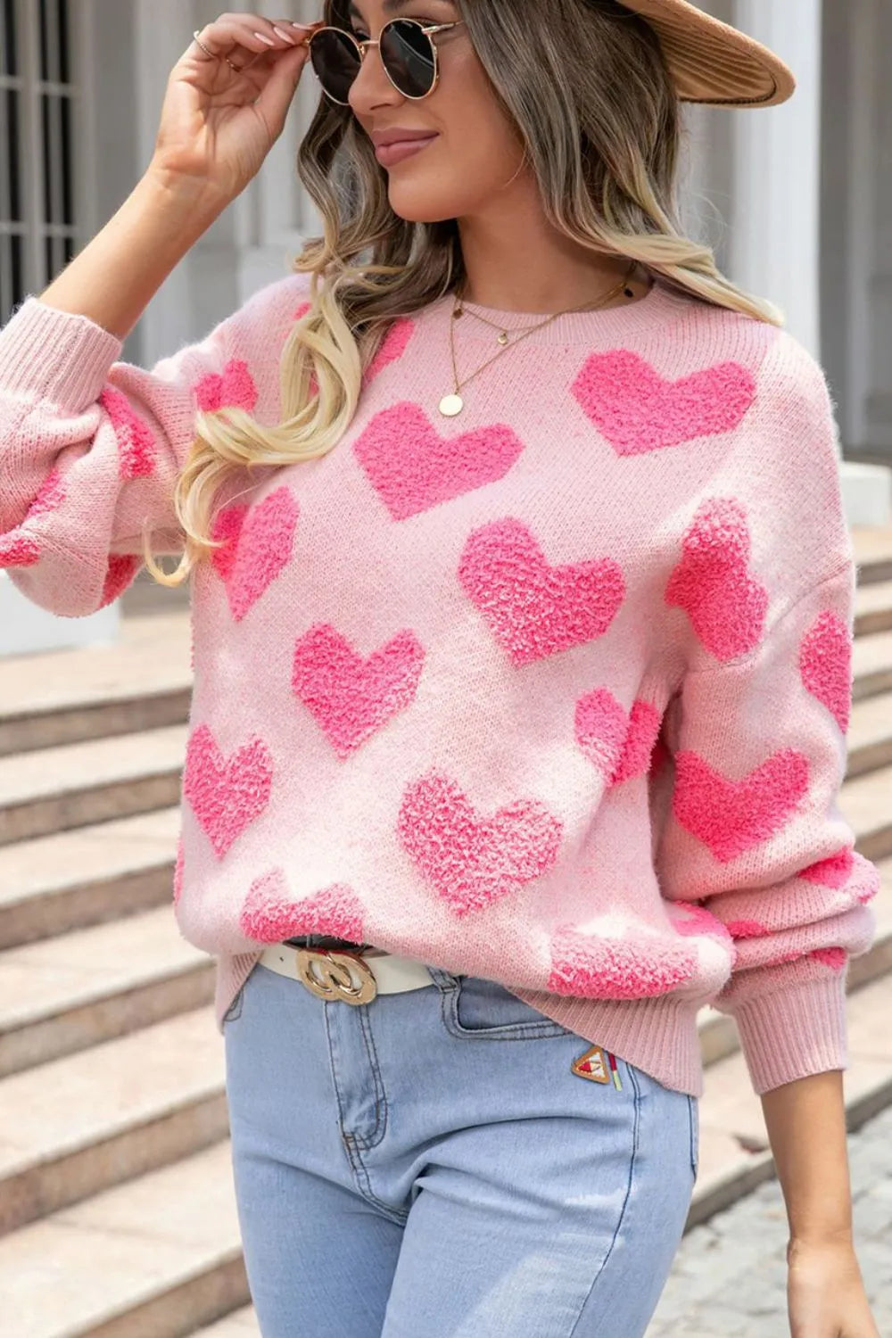 Blush pink round neck sweater with textured heart jacquard pattern, ribbed cuffs and hem.