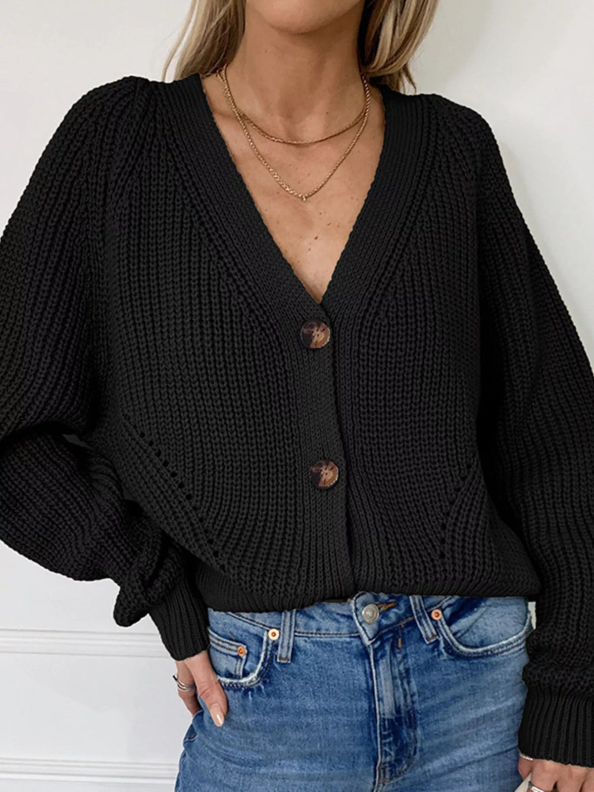Black chunky knit cardigan with large tortoiseshell buttons and a deep V-neckline.