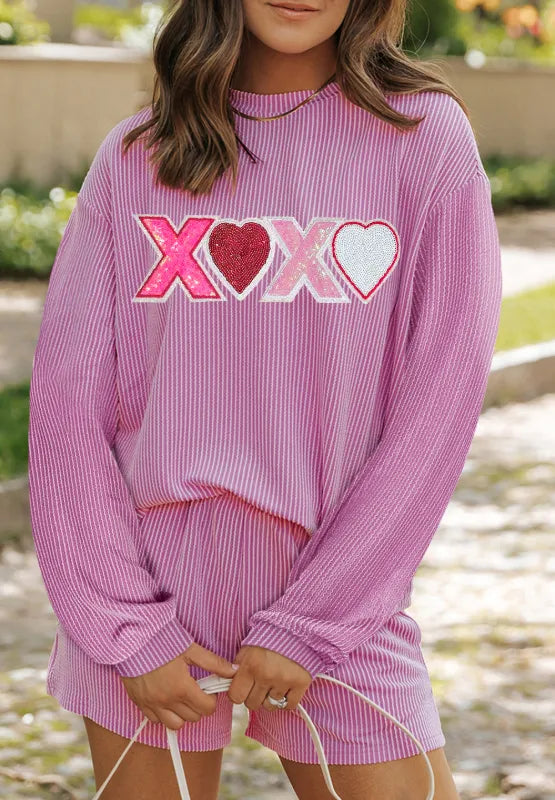 Pink long sleeve top with XOXO sequin hearts paired with matching pink shorts.