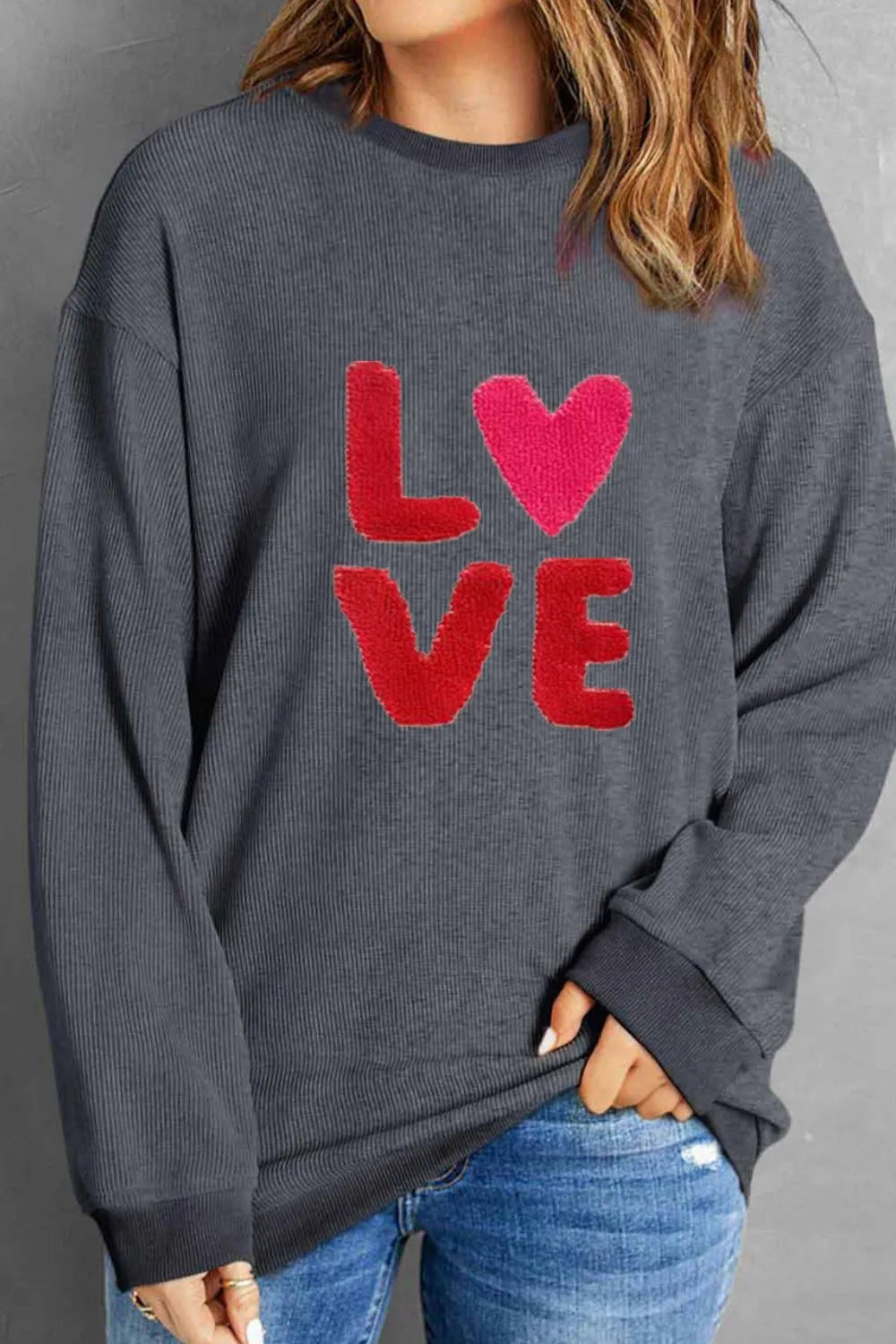 Dark gray long sleeve sweatshirt with red "LOVE" text and heart graphic on front.