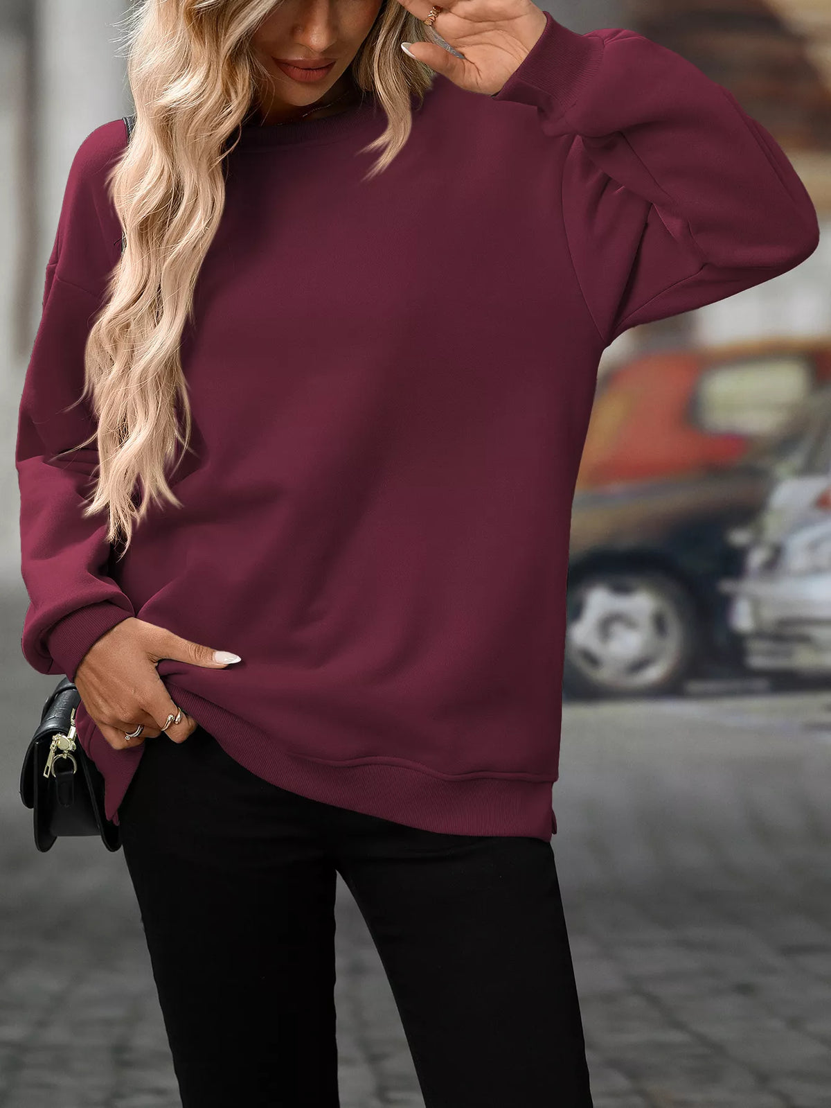 Burgundy long sleeve sweatshirt with crew neck and relaxed fit, worn with black pants.