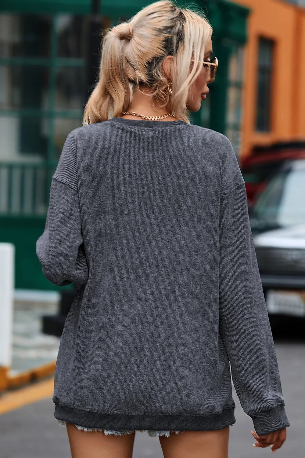 Dark gray long sleeve sweatshirt with round neck and relaxed fit, worn from the back.