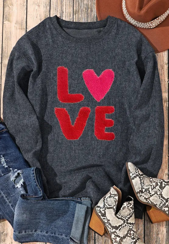 Dark gray long sleeve sweatshirt with red and pink "LOVE" lettering and heart graphic on front.