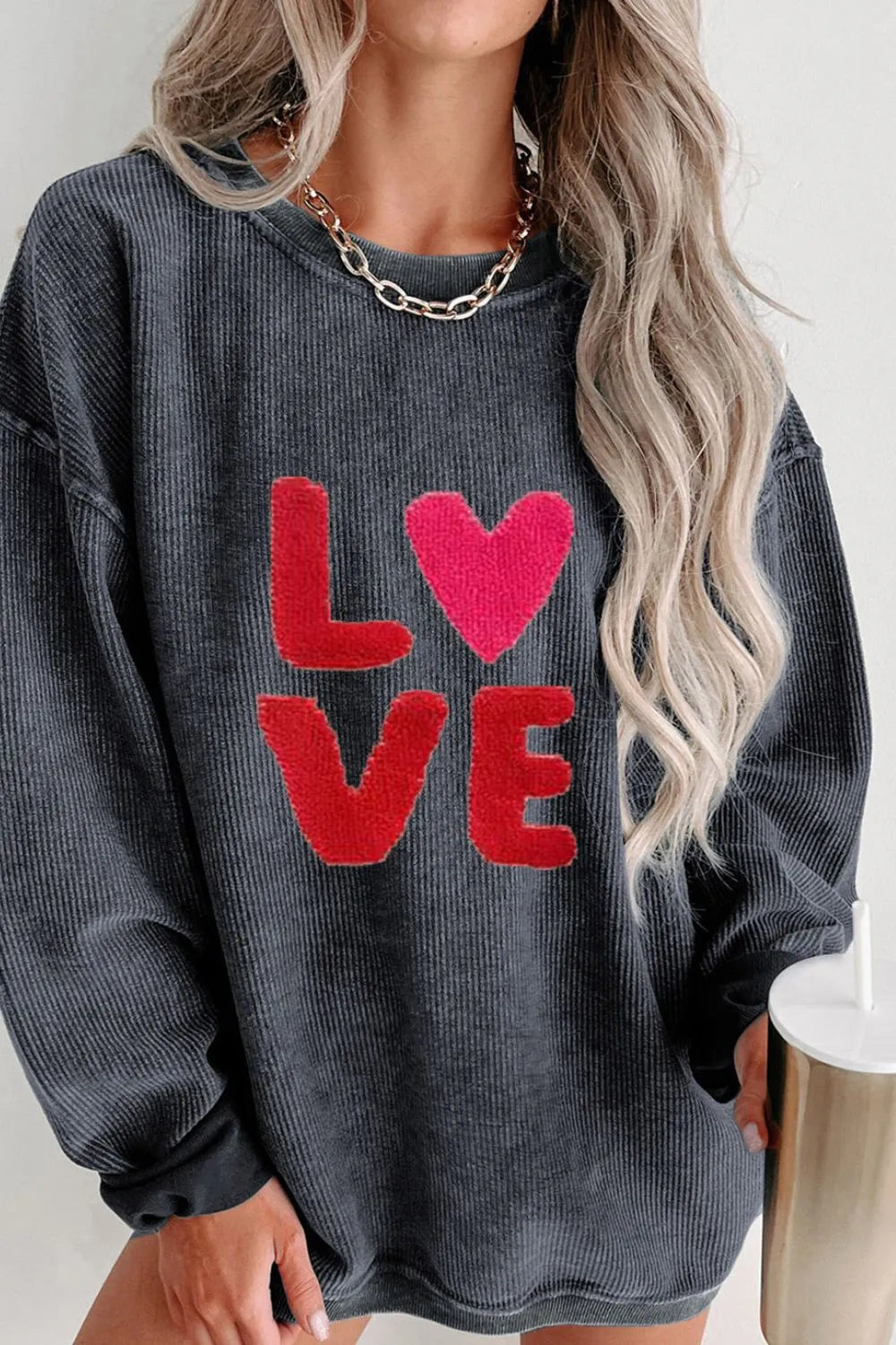 Dark gray sweatshirt with red "LOVE" text and heart graphic, round neck and long sleeves.