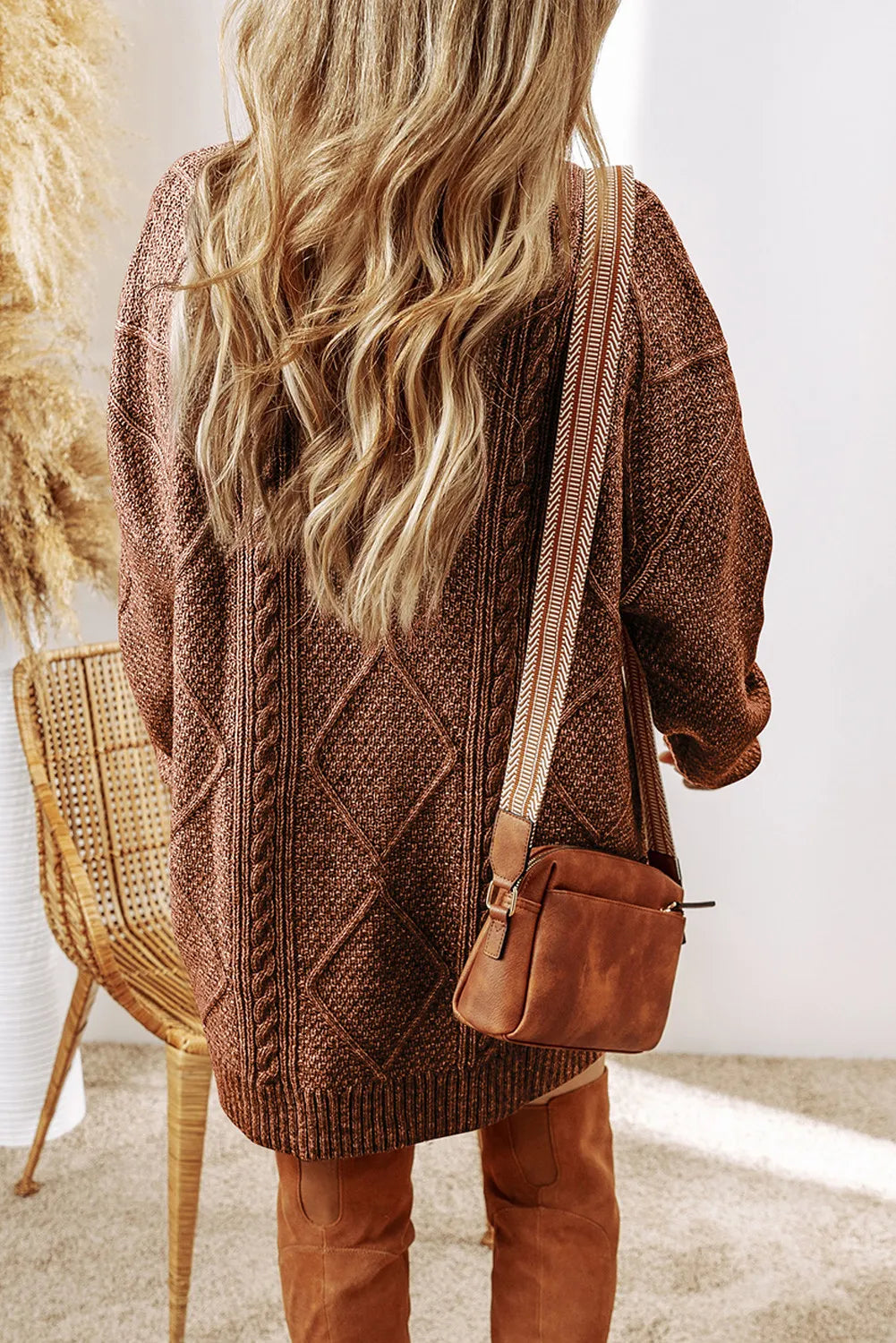 Taupe cable-knit round neck sweater dress with diamond pattern and loose fit shown from back.