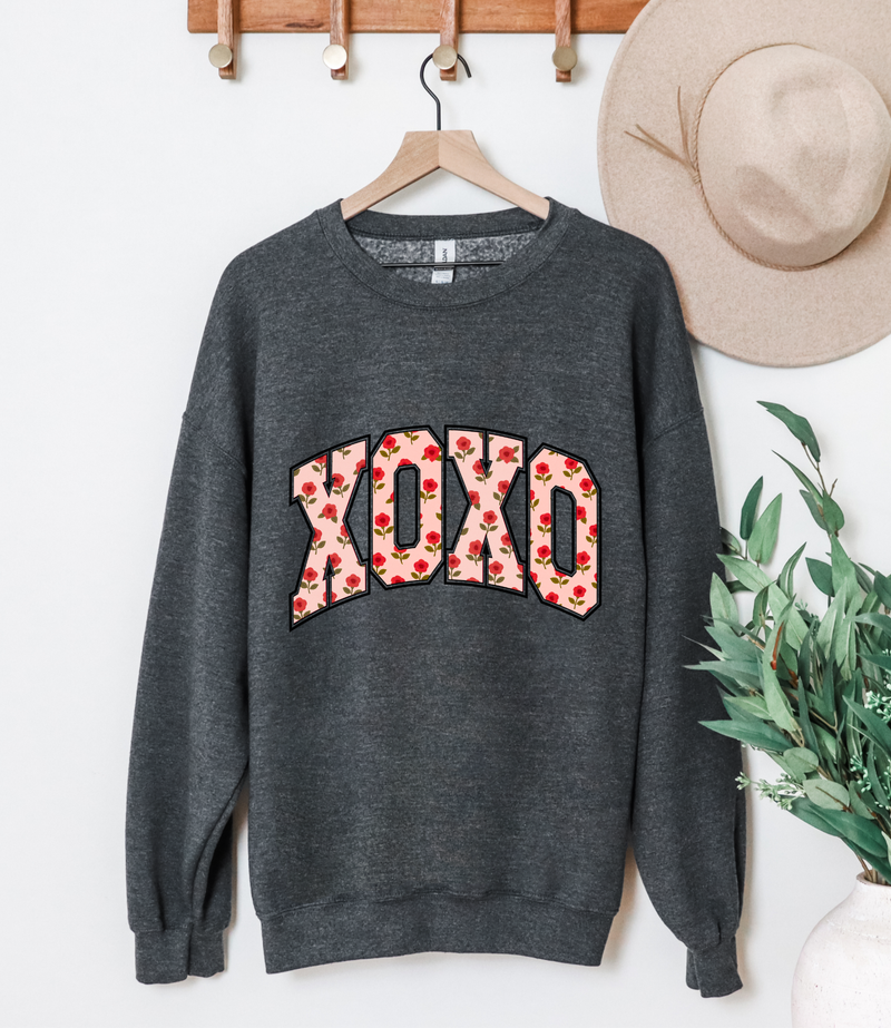 Charcoal gray sweatshirt with large floral "XOXO" graphic on front, crew neck, ribbed cuffs and hem.