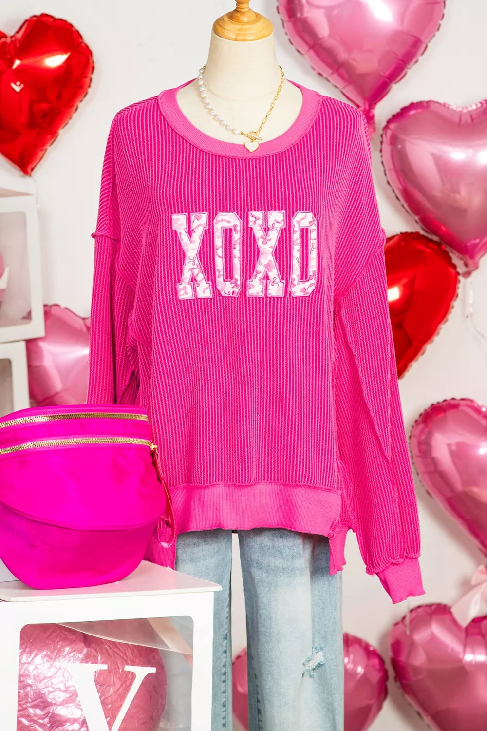 Hot pink long sleeve ribbed top with white XOXO text, relaxed fit, crew neck.