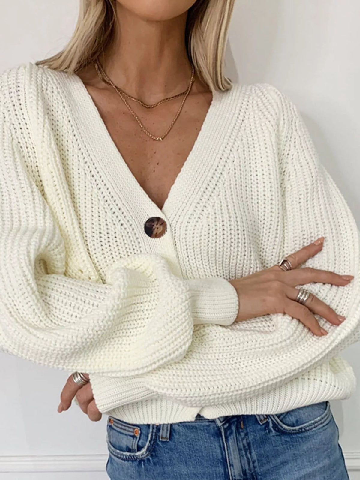 Cream white chunky knit cardigan with oversized sleeves and tortoiseshell buttons.