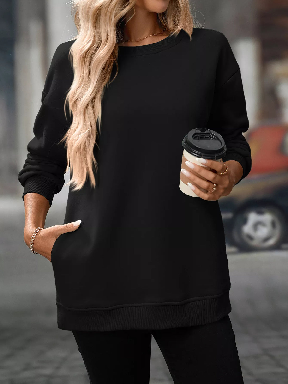 Black casual long sleeve sweatshirt with ribbed cuffs and hem, worn with relaxed fit.