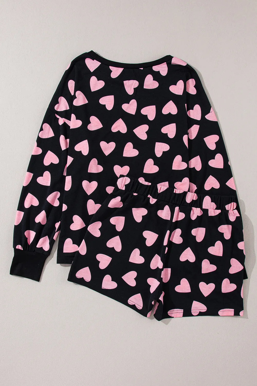 Black long sleeve top and matching shorts lounge set with all-over pink heart print.