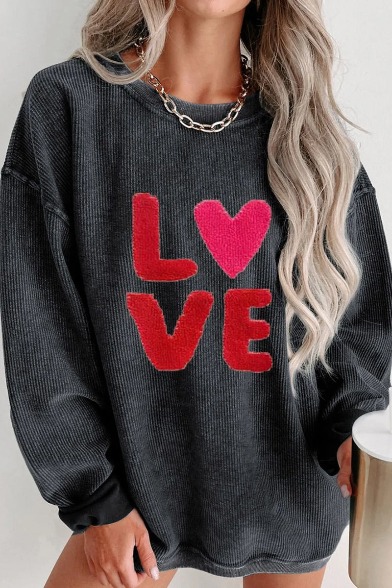 Dark gray long sleeve sweatshirt with bold red "LOVE" and heart graphic on front.